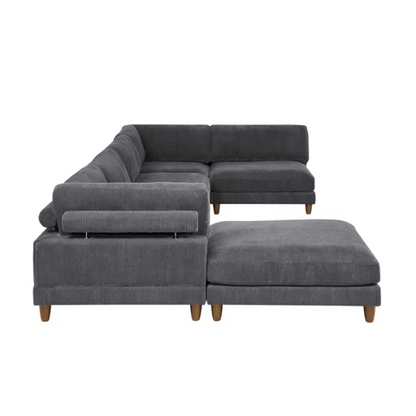 Dark grey modular sectional sofa with soft corduroy upholstery, matching ottoman, and removable cushions — seats six with flexible L- or U-shaped configurations.

