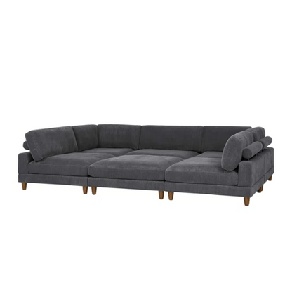 Dark grey modular sectional sofa with soft corduroy upholstery, matching ottoman, and removable cushions — seats six with flexible L- or U-shaped configurations.

