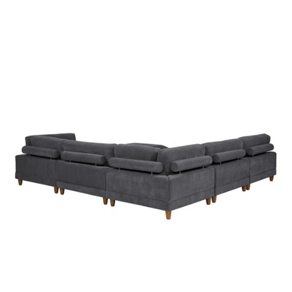 Dark grey modular sectional sofa with soft corduroy upholstery, matching ottoman, and removable cushions — seats six with flexible L- or U-shaped configurations.

