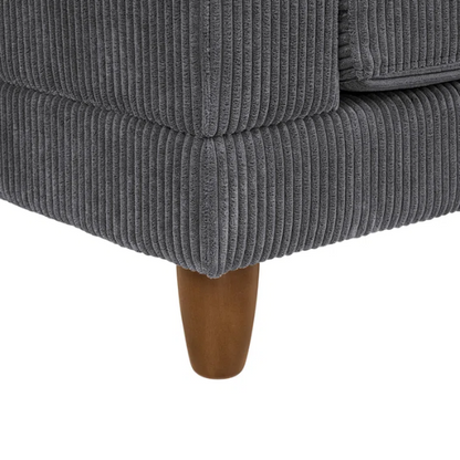 Dark grey modular sectional sofa with soft corduroy upholstery, matching ottoman, and removable cushions — seats six with flexible L- or U-shaped configurations.

