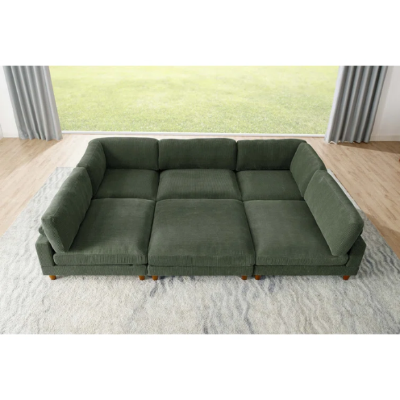 Olive drab green modular sectional sofa with soft corduroy upholstery, removable cushions, and matching ottoman — seats six with L-shaped or U-shaped layout options.


