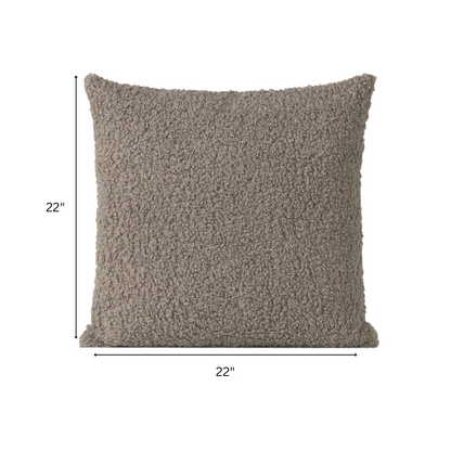Grey bouclé throw pillow with soft looped texture, square accent pillow on a modern neutral-toned sofa

