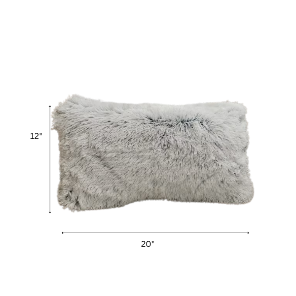 Set of two grey faux fur throw pillows with fluffy texture on a neutral-toned sofa in a modern living room

