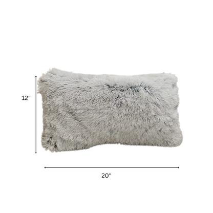 Set of two grey faux fur throw pillows with fluffy texture on a neutral-toned sofa in a modern living room

