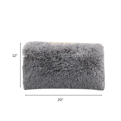 Set of two grey faux fur throw pillows with plush texture on a modern sofa

