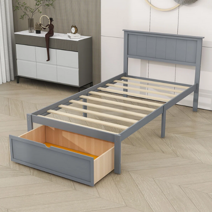 Grey twin platform bed made from solid pine wood with a rectangular headboard and a pull-out underbed storage drawer, featuring sturdy center support legs and a clean modern finish.

