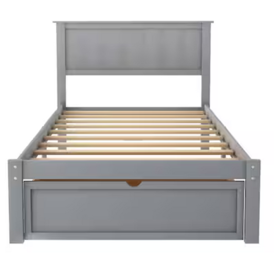 Grey twin platform bed made from solid pine wood with a rectangular headboard and a pull-out underbed storage drawer, featuring sturdy center support legs and a clean modern finish.

