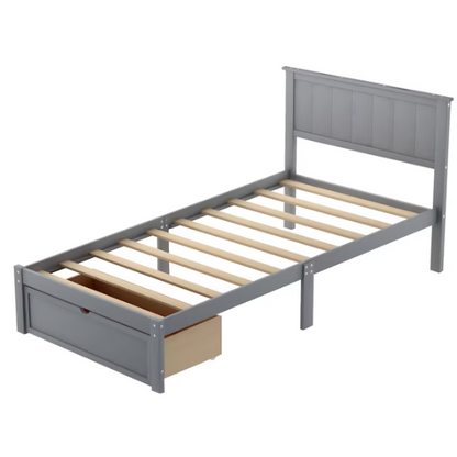 Grey twin platform bed made from solid pine wood with a rectangular headboard and a pull-out underbed storage drawer, featuring sturdy center support legs and a clean modern finish.

