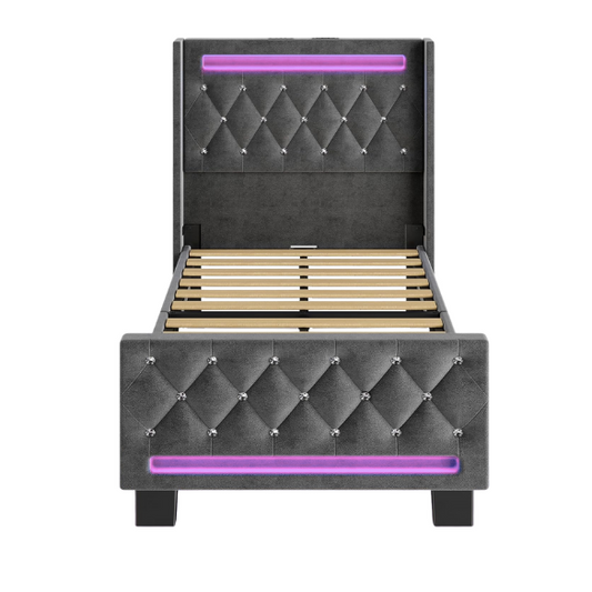 Modern grey twin bed with LED lights, USB charging ports, and upholstered velvet headboard and footboard – no box spring required
