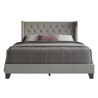 Grey upholstered full-size bed with tufted wingback headboard and nailhead trim