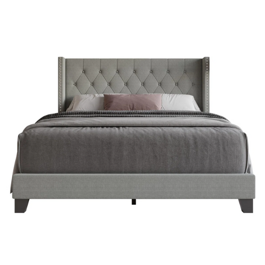 Grey upholstered full-size bed with tufted wingback headboard and nailhead trim