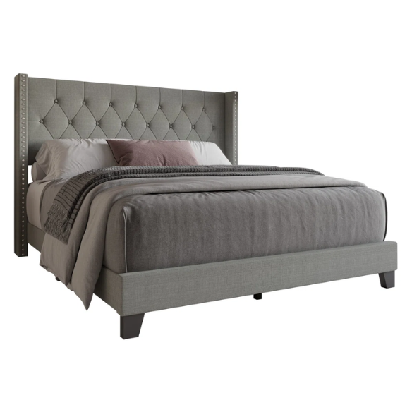 Grey upholstered full-size bed with tufted wingback headboard and nailhead trim