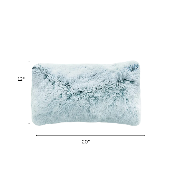 Set of two ice blue and white ombré faux fur throw pillows with shaggy texture on a modern light-toned sofa

