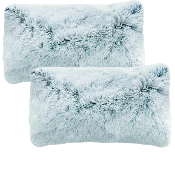 Set of two ice blue and white ombré faux fur throw pillows with shaggy texture on a modern light-toned sofa

