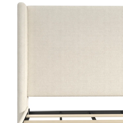Ivory bouclé upholstered king-size platform bed with tall wingback headboard, wood slats, and no box spring required.

