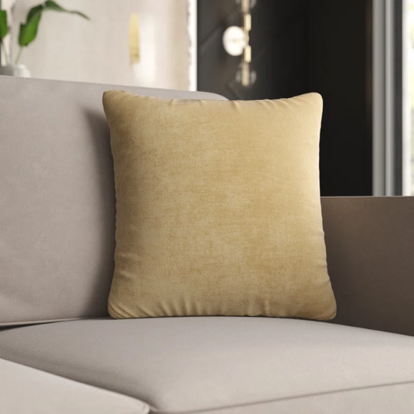 Light gold crushed velvet throw pillow, 16x16 square with soft texture and reversible design, styled in a neutral living space for a touch of subtle shine.

