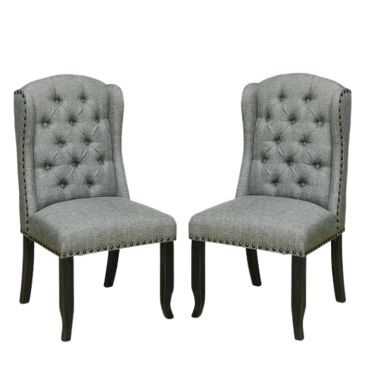 Set of two light grey farmhouse-style wingback dining chairs with button tufting, nailhead trim, and antique black tapered legs