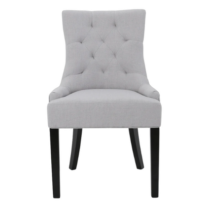 Set of four light grey upholstered dining chairs with diamond tufted backs, armless design, sloped armrests, and espresso brown wood legs.

