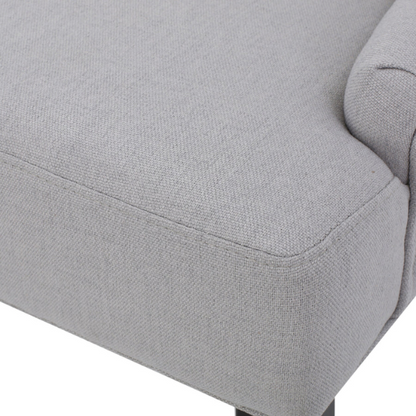 Set of four light grey upholstered dining chairs with diamond tufted backs, armless design, sloped armrests, and espresso brown wood legs.

