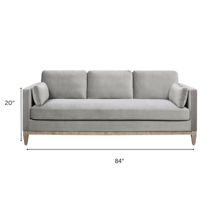 Light grey velvet 3-seater sofa with feather-down cushions, track arms, and natural wood legs, designed for modern and transitional spaces.

