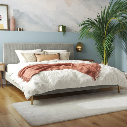Light grey velvet king-size platform bed with upholstered headboard and wood slats, modern design, no box spring required.

