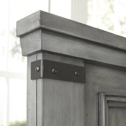 King-size storage bed in light weathered gray finish with tall panel headboard, footboard drawers, and dark bronze hardware accents

