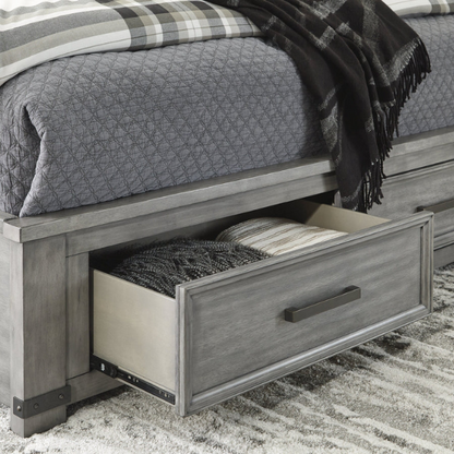 King-size storage bed in light weathered gray finish with tall panel headboard, footboard drawers, and dark bronze hardware accents

