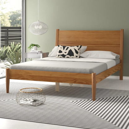 Mid-century modern full-size solid wood platform bed in medium light brown with rectangular headboard and tapered legs