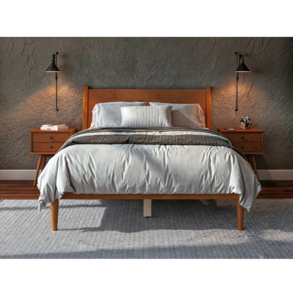 Mid-century modern full-size solid wood platform bed in medium light brown with rectangular headboard and tapered legs