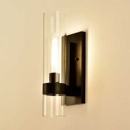 Modern black wall sconce with cylindrical clear glass shade – contemporary uplight fixture for bathrooms, hallways, or bedrooms

