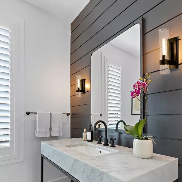 Modern black wall sconce with cylindrical clear glass shade – contemporary uplight fixture for bathrooms, hallways, or bedrooms

