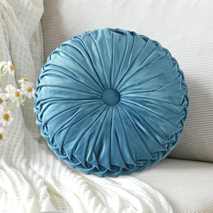 Muted blue velvet round throw pillows with pleated detailing and button center, 14.5-inch set of two styled on a neutral-toned sofa.

