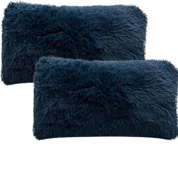 Set of two navy blue faux fur throw pillows with shaggy texture on a neutral-toned modern sofa

