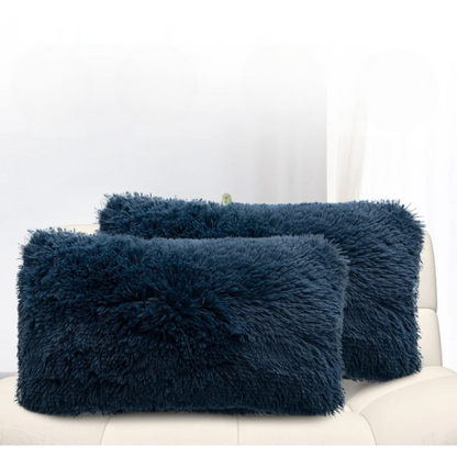 Set of two navy blue faux fur throw pillows with shaggy texture on a neutral-toned modern sofa

