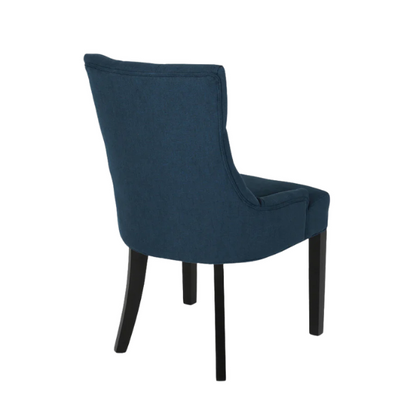 Set of four navy blue upholstered dining chairs featuring diamond tufted backs, armless design, sloped sides, and espresso brown wooden legs.

