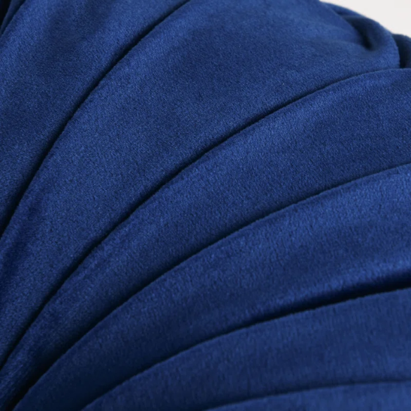 Navy blue velvet round throw pillows with hand-sewn pleats and button center, 14.5-inch set of two styled on a neutral-toned sofa.

