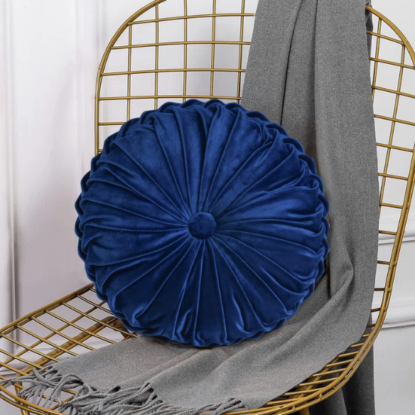 Navy blue velvet round throw pillows with hand-sewn pleats and button center, 14.5-inch set of two styled on a neutral-toned sofa.

