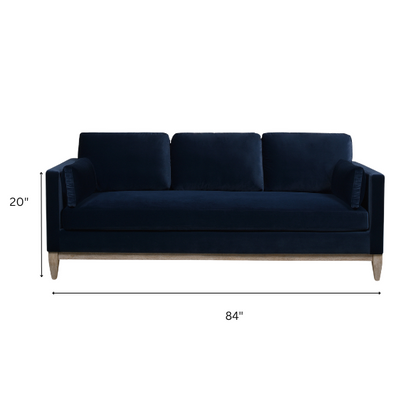Navy blue velvet 3-seater sofa with feather-down cushions, track arms, and solid wood legs, designed for modern and transitional interiors.

