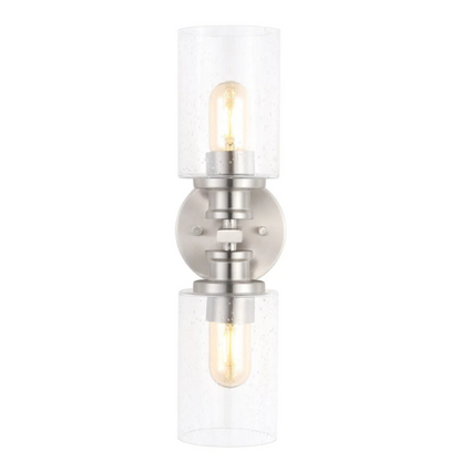Brushed nickel wall sconce with two clear seeded glass cylinder shades and Edison-style LED bulbs, perfect for bathrooms or hallway accent lighting


