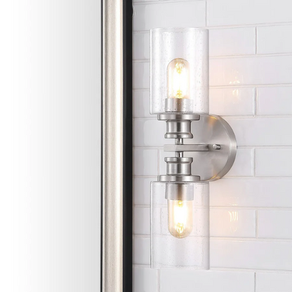 Brushed nickel wall sconce with two clear seeded glass cylinder shades and Edison-style LED bulbs, perfect for bathrooms or hallway accent lighting

