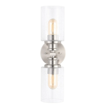 Brushed nickel wall sconce with two clear seeded glass cylinder shades and Edison-style LED bulbs, perfect for bathrooms or hallway accent lighting

