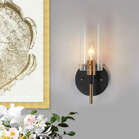 Nordic modern wall sconce with matte black finish, electroplated brass arm, and clear cylindrical glass shade – stylish uplight or downlight fixture


