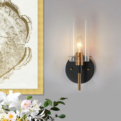 Nordic modern wall sconce with matte black finish, electroplated brass arm, and clear cylindrical glass shade – stylish uplight or downlight fixture

