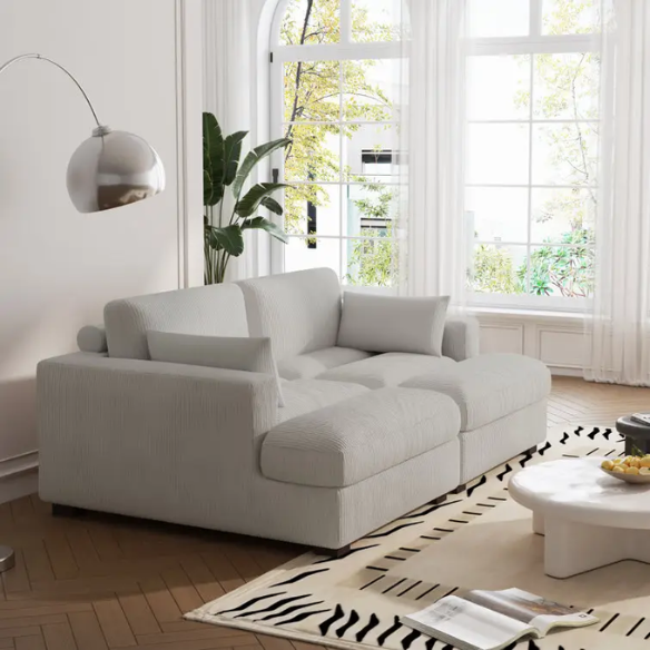 Off-white corduroy convertible sleeper sofa with adjustable headrest, twin bed functionality, and mid-century wooden legs