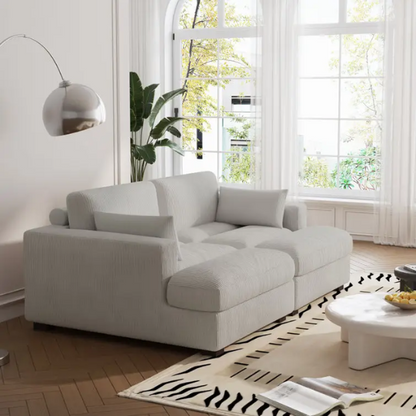 Off-white corduroy convertible sleeper sofa with adjustable headrest, twin bed functionality, and mid-century wooden legs