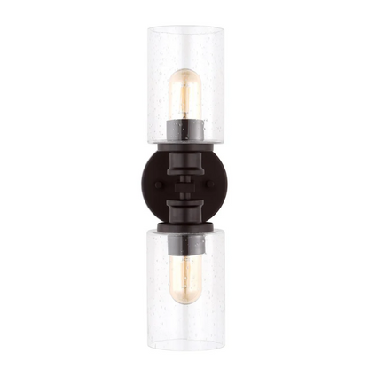Oil-rubbed bronze wall sconce with dual clear seeded glass cylinder shades and Edison-style LED bulbs, perfect for rustic, farmhouse, or traditional interiors

