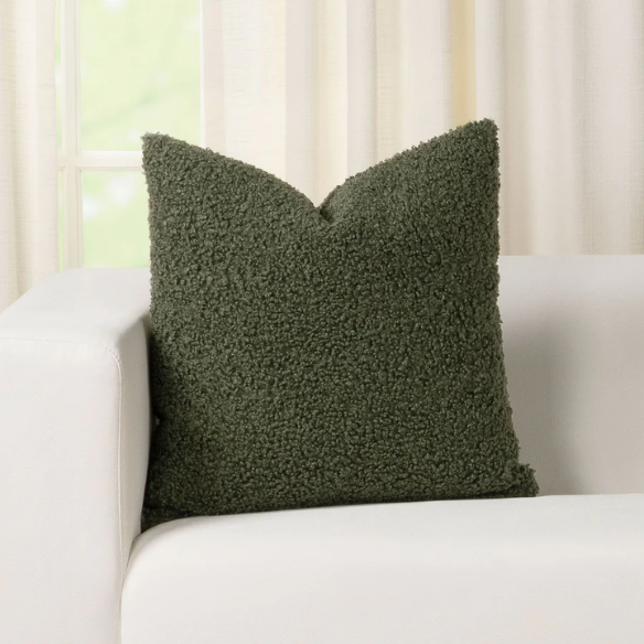 Olive drab bouclé throw pillow with textured loop fabric, square accent pillow on neutral sofa

