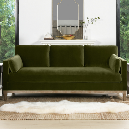 Olive green velvet 3-seater sofa with track arms, feather-down cushions, and natural wood base, ideal for modern and transitional living rooms.

