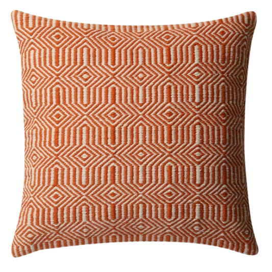 Orange and cream geometric throw pillow on a modern patio chair with bright outdoor decor

