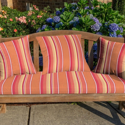 Striped accent pillow in vibrant orange, red, yellow, and white – reversible, weather-resistant, and overstuffed with polyester fill for indoor or outdoor use.

